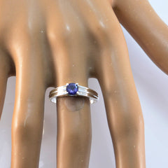 Emi silver band blue solitaire ring for women with round blue gemstone shown on display hand