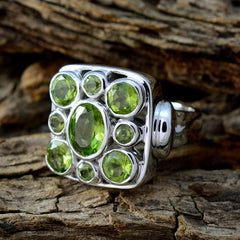 Nia navratna green gemstone ring with central oval and eight round peridot stones in sterling silver