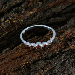 Yan abstract red gemstone ring with five red stones set in silver band on rustic wood