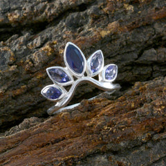 Naomi sterling silver ring with marquise and pear blue stones shaping a blue gemstone crown ring on bark backdrop