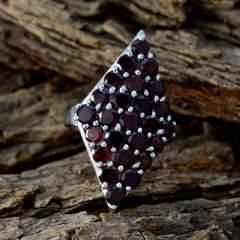 Natcha red gemstone statement ring diamond shaped cluster of round deep red stones in silver prong setting on wood background