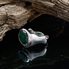 Savannah green solitaire ring with oval emerald bezel set in polished silver wide band on reflective black surface