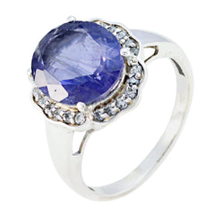 Laura blue halo ring for women with a large oval blue gemstone surrounded by small clear stones in silver band