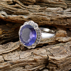 Laura blue halo ring for women with oval blue gemstone and silver band displayed on rustic wood