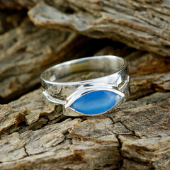 Anna silver band blue solitaire ring with marquise-shaped blue stone on rustic wood background