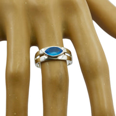 Anna blue solitaire ring with marquise blue gemstone set in a polished silver band on a display hand