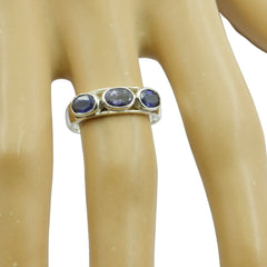 Lily blue trilogy gemstone ring with three oval blue stones set on silver band worn on finger