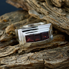 Katharina ethnic red gemstone ring with three square red stones set in a silver band on rustic wood