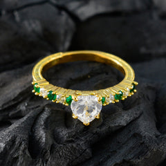 Angel gold ring featuring a heart-shaped clear center stone with green gemstone statement ring accents