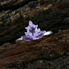 Lakshmi crown ring purple with silver band and purple gemstone petals on rustic wood background