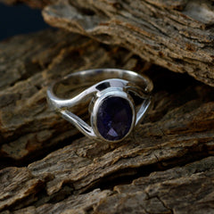 Ananya modern blue gemstone ring with oval blue stone and silver band on rustic wooden surface
