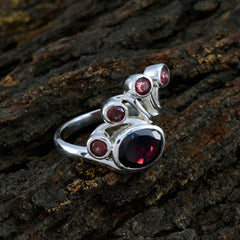 Nayara modern red gemstone ring with multiple red stones set in silver band on textured background