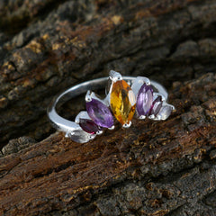Li Lee multicolor gemstone crown ring with purple and yellow stones on silver band on textured wood