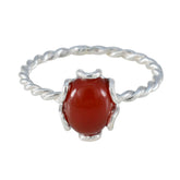 Ying red gemstone solitaire ring with twisted silver band and smooth oval red stone centerpiece