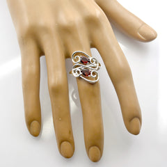 Cecilia red gemstone toi et moi ring with two red stones and silver swirl design on finger