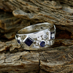 Lucia abstract blue gemstone ring with silver band featuring multiple blue stones on rustic wood