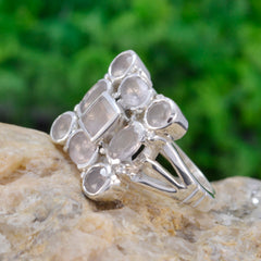 Hazel abstract pink navratna ring with multiple pink gemstones in silver setting on stone surface