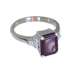 Liyana abstract red halo ring featuring a rectangular red gemstone with small clear stones on a silver band