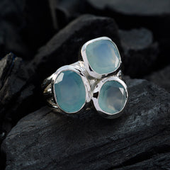 Sarah aqua gemstone trilogy ring with three light blue stones set in silver on black stone background
