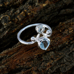 Natcha artisan blue gemstone ring with silver band featuring two blue stones on textured dark wood background