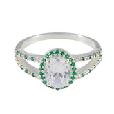 Joaquina artisan green halo ring with oval clear center stone and green gemstones surrounding silver band