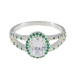 Joaquina artisan green halo ring with oval clear center stone and green gemstones surrounding silver band