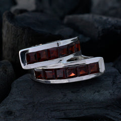 Isla artisan red gemstone ring with square red stones set in a silver band on dark textured background