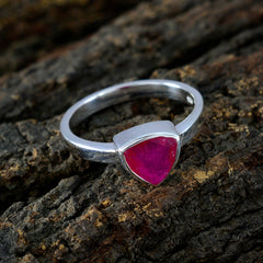 Patricia artisan red solitaire ring with triangular red stone set in silver band on textured wood