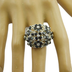 Daniela black floral statement ring featuring black stones and silver floral design on finger