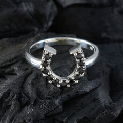 Liyana black gemstone statement ring with silver horseshoe design on dark textured background