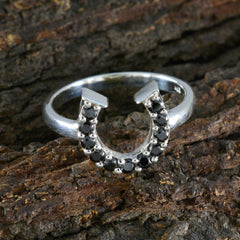 Liyana black gemstone statement ring with silver horseshoe design on rustic bark background