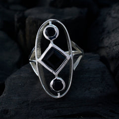 Lea black gemstone trilogy ring featuring three black stones in a silver setting on dark background