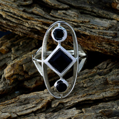 Lea black gemstone trilogy ring with geometric design on rustic wood background