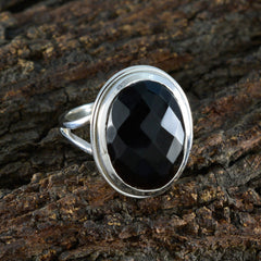 Dewi silver ring with large faceted oval black onyx in bezel setting black solitaire ring for women on bark background