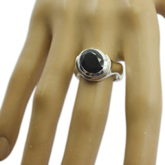 Araya black solitaire ring with a large round black gemstone on a silver band worn on finger