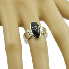 Mila black solitaire ring with oval black stone set in a silver band on a display hand