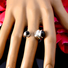 Lucy black toi et moi ring silver open band with two black cabochons on mannequin hand with rose petals