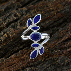Angel blue gemstone leaf ring with deep blue stones and silver band on textured wood background
