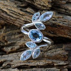 Ananya blue gemstone leafy ring with multiple faceted blue stones set in a silver band on rustic wood