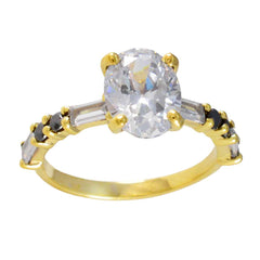 Riya gold ring with large clear center stone and small black side stones, blue gemstone statement ring