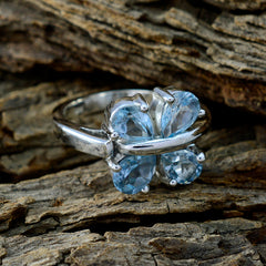 Laura sterling silver ring with four pale blue gemstones arranged like a flower on wood background blue gemstone statement ring