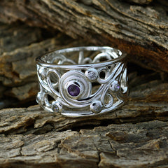 Dayana silver ring with intricate design featuring a central blue gemstone statement ring on rustic wood