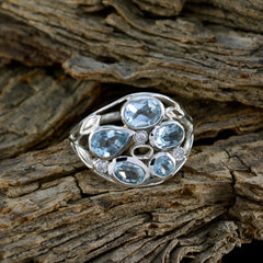 Julieta silver blue gemstone statement ring with multiple light blue stones on rustic wood background