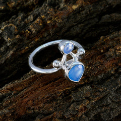 Riley blue gemstone toi et moi ring with silver band on rustic wood background