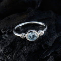 Nari elegant silver blue gemstone trilogy ring with one large and two smaller stones on black surface
