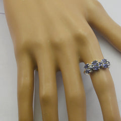 Marie blue gemstone trilogy ring with three oval blue stones set in silver band on mannequin hand