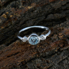 Nari blue gemstone trilogy ring with a round center stone and two smaller side stones on silver band