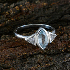 Chen silver blue gemstone trilogy ring with marquise center stone and triangular side stones on wood