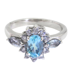 Lili blue gemstone trilogy ring with oval center stone and surrounding smaller gems in silver band