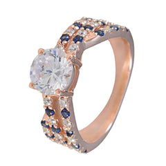 Florencia blue halo engagement ring with large central diamond and blue sapphire accents on rose gold band